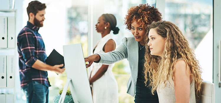 A woman listens as a manager goes over her work.
