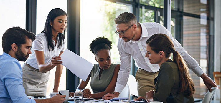 An accountant works at a conference table with staff.