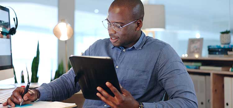 businessman in home office reads from tablet