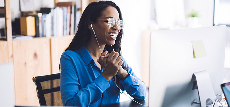 businesswoman in remote meeting laughs at colleague comment