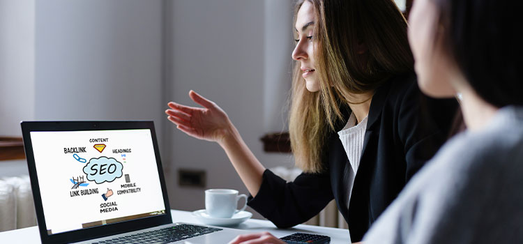 A woman explains a graphic about search engine optimization (SEO) to a coworker