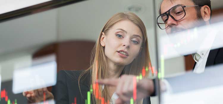 male financial analyst describing data to female intern