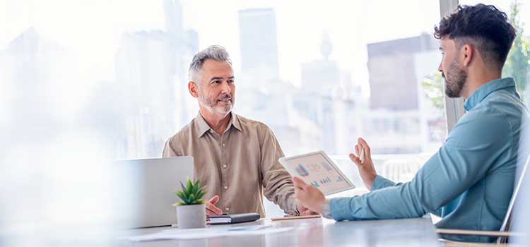man discussing business plan with man at table