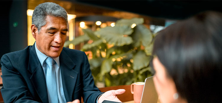 A man explains information on a pad to a women in