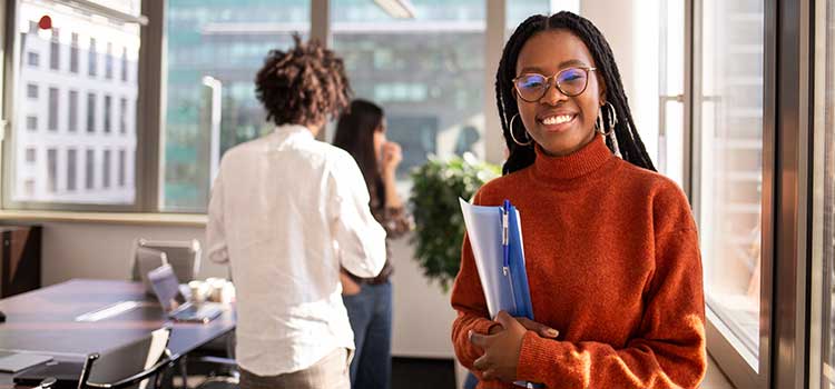 business student holds books in classroom with classmates