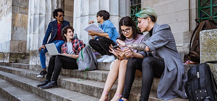 Students gather on building steps and talk