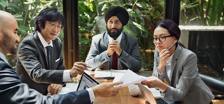 Colleagues around a table share documents