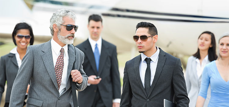 A group of businesspeople on a tarmac arriving for a meeting