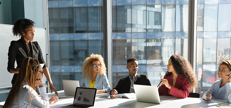 A manager listens as a staffer speaks at a meeting