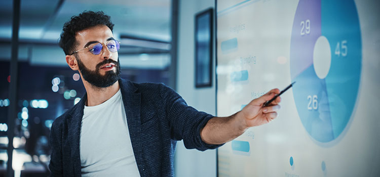 digital marketing manager shows team latest site data on projected screen