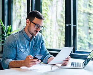 an accounting professional works at his computer and decides if he is going to get a master's degree
