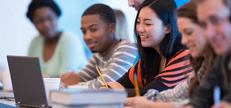 group of students looking at laptop
