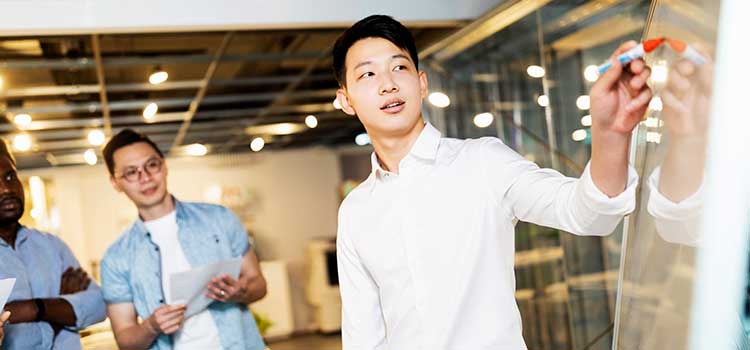 project manager pointing to white board