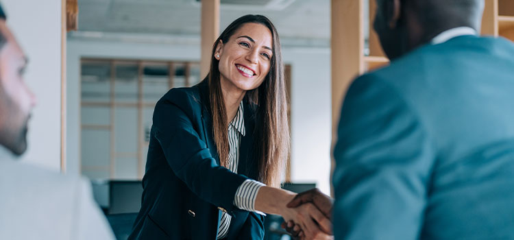 A female job candidate shakes hands with a man